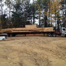 Truck rolls in with the roof trusses and other supplies.