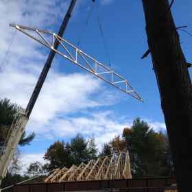 Crane lifting roof trusses into place.