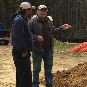 Dan's Paving & Excavating meets with Construction Manager John Smith about the layout of the sewer and gas lines on site.